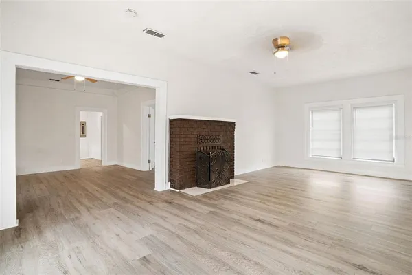 a view of empty room with wooden floor
