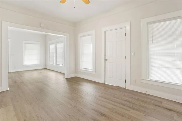 an empty room with wooden floor and a window