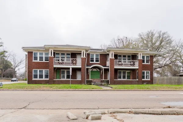 a front view of building with yard and green space