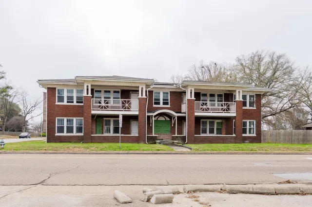 a front view of building with yard and green space