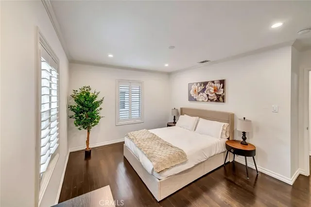 a bedroom with a large bed and a potted plant