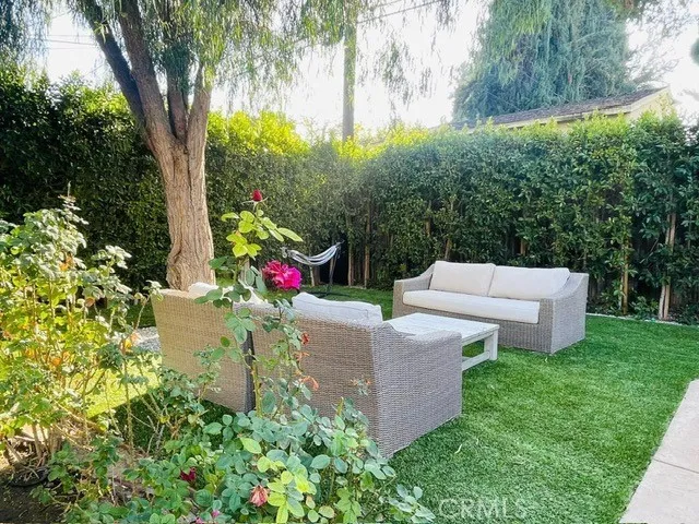 a view of a garden with potted plants and large trees