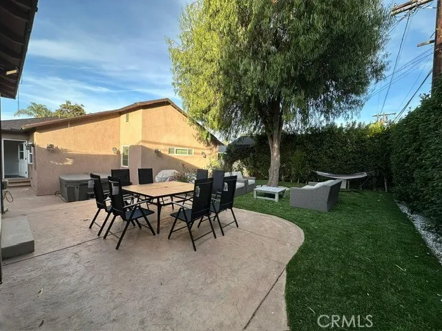 a view of a patio with table and chairs potted plants with large tree