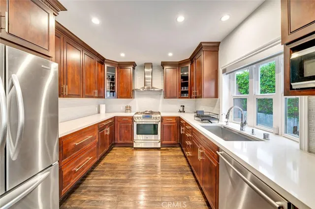 a large kitchen with stainless steel appliances granite countertop a sink a stove top oven a refrigerator with island and windows