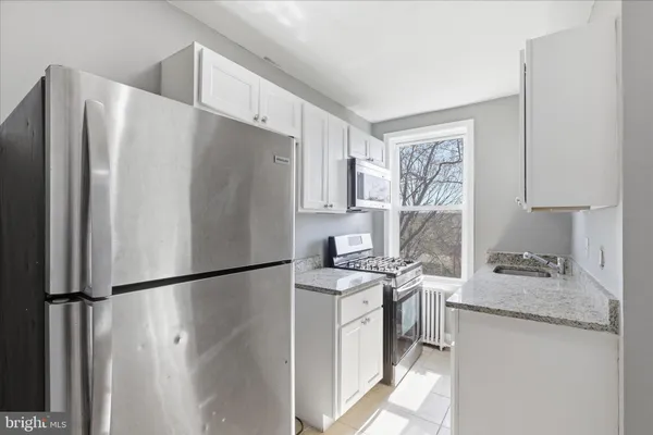 a kitchen with stainless steel appliances granite countertop a refrigerator sink and stove