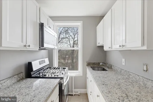 a kitchen with white cabinets and appliances