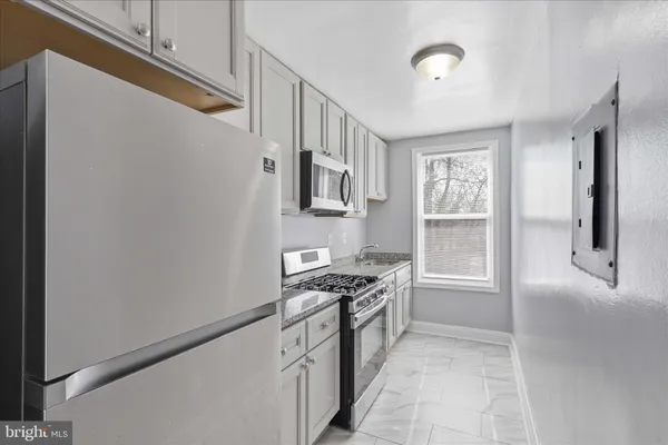 a kitchen with stainless steel appliances granite countertop a stove and a refrigerator
