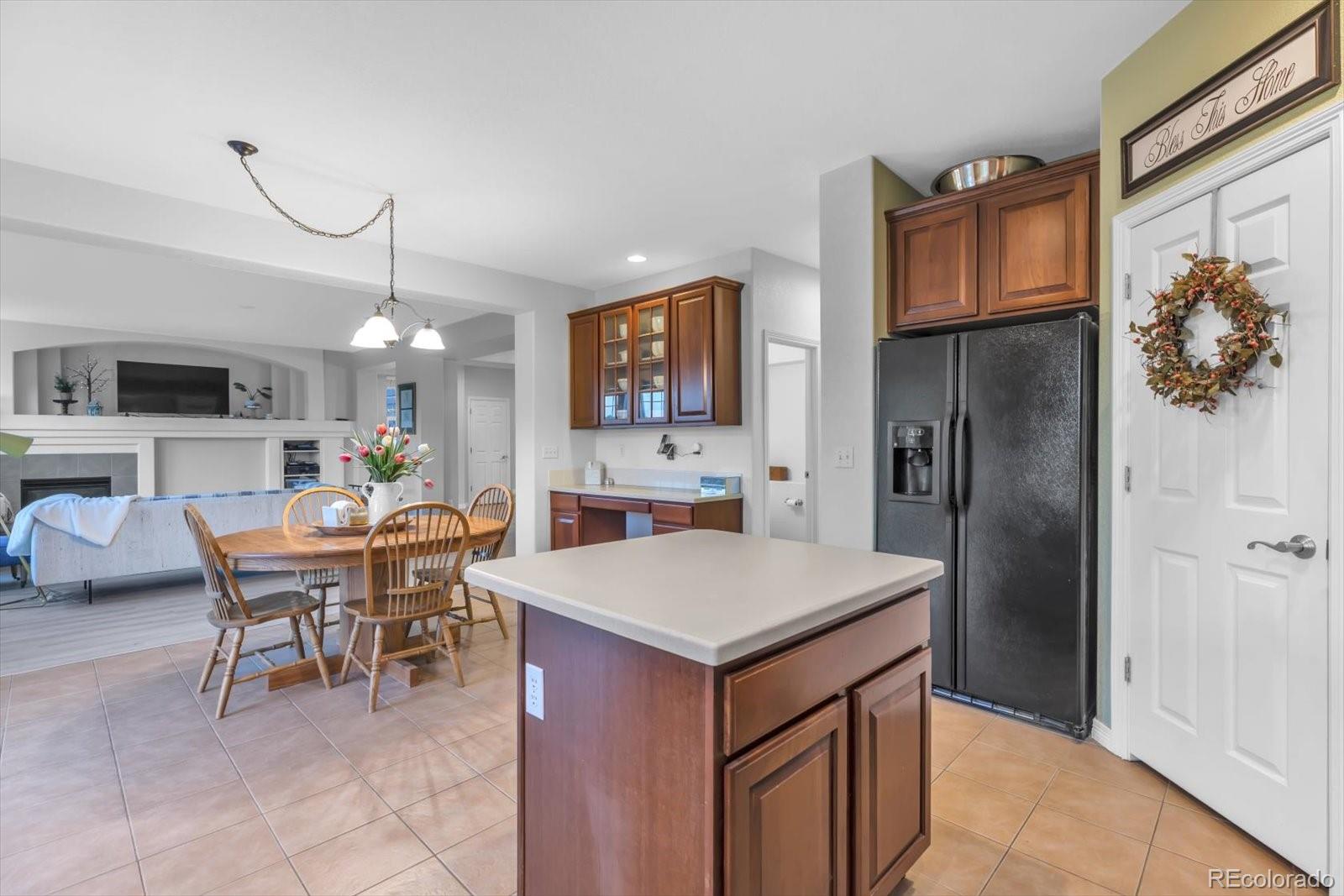 4786 Rabbit Mountain Road Broomfield, CO 80020 - Photo 10 of 41 a kitchen with a table chairs refrigerator and cabinets