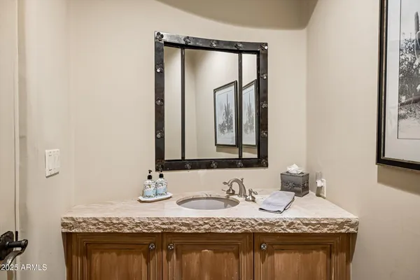 a bathroom with a granite countertop sink and a mirror