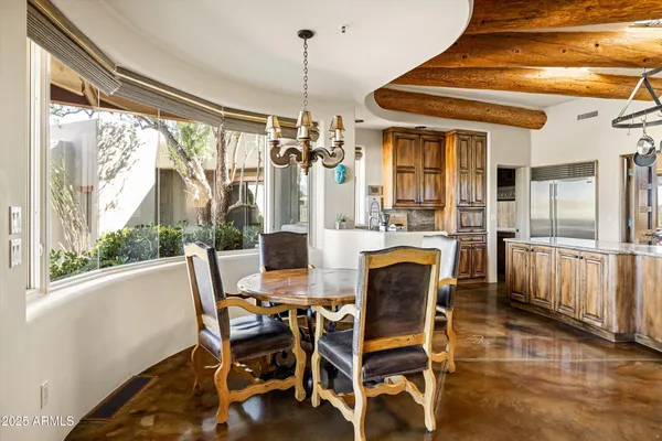 a dining room with furniture a chandelier and wooden floor