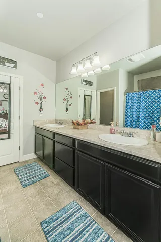 a spacious bathroom with a granite countertop sink a mirror and a