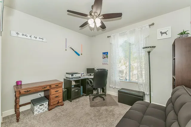 a view of a workspace with furniture and a window