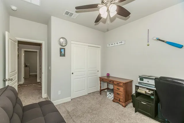 a livingroom with workspace and a ceiling fan