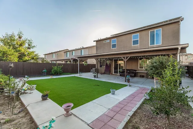 a view of a house with backyard sitting area and garden