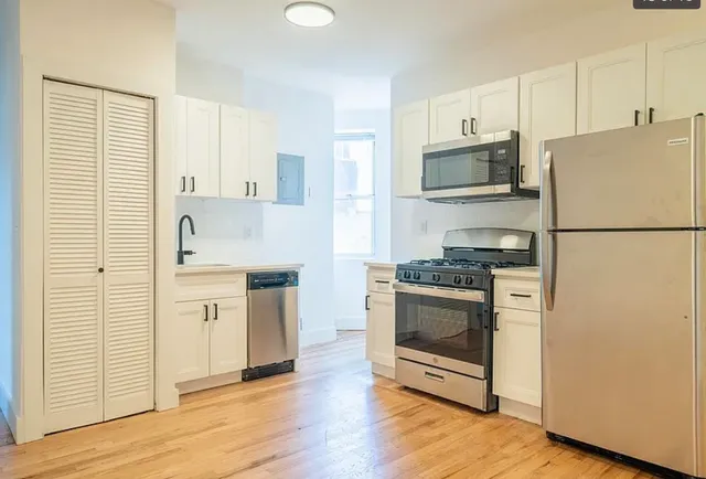 a kitchen with stainless steel appliances a refrigerator stove and microwave