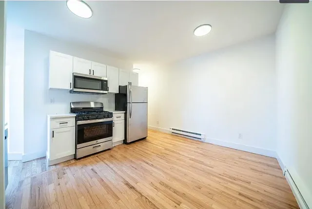 a kitchen with granite countertop a refrigerator and a stove top oven