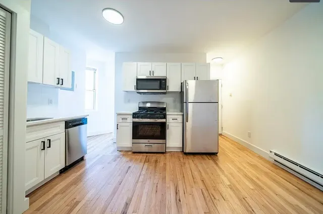 a kitchen with a refrigerator and a stove top oven