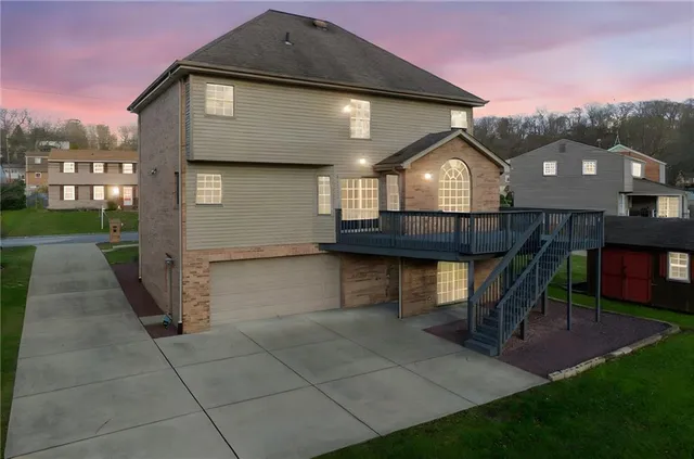 a front view of a house with a yard and a garden