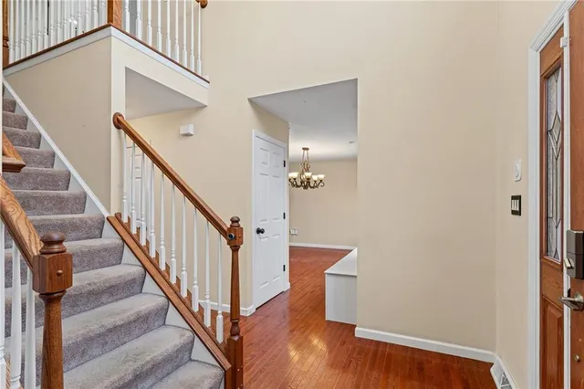 a view of a hallway with wooden floor and stairs