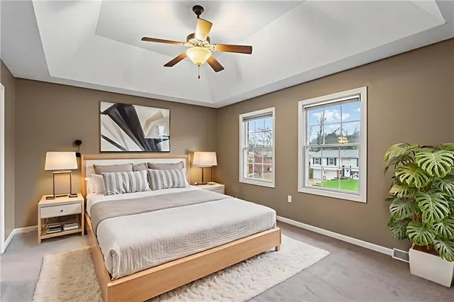 a bedroom with a bed next to a window and a chandelier