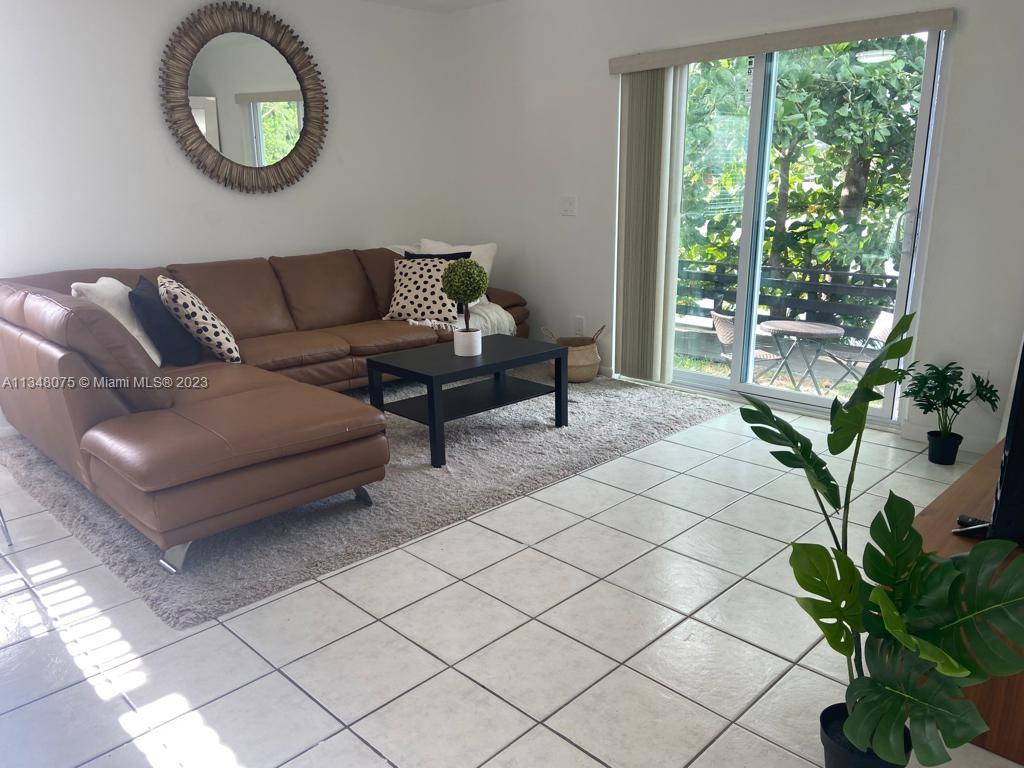 1016 Southwest 8th Street Hallandale Beach, FL 33009 - Photo 7 of 18 a living room with furniture a potted plant and a window