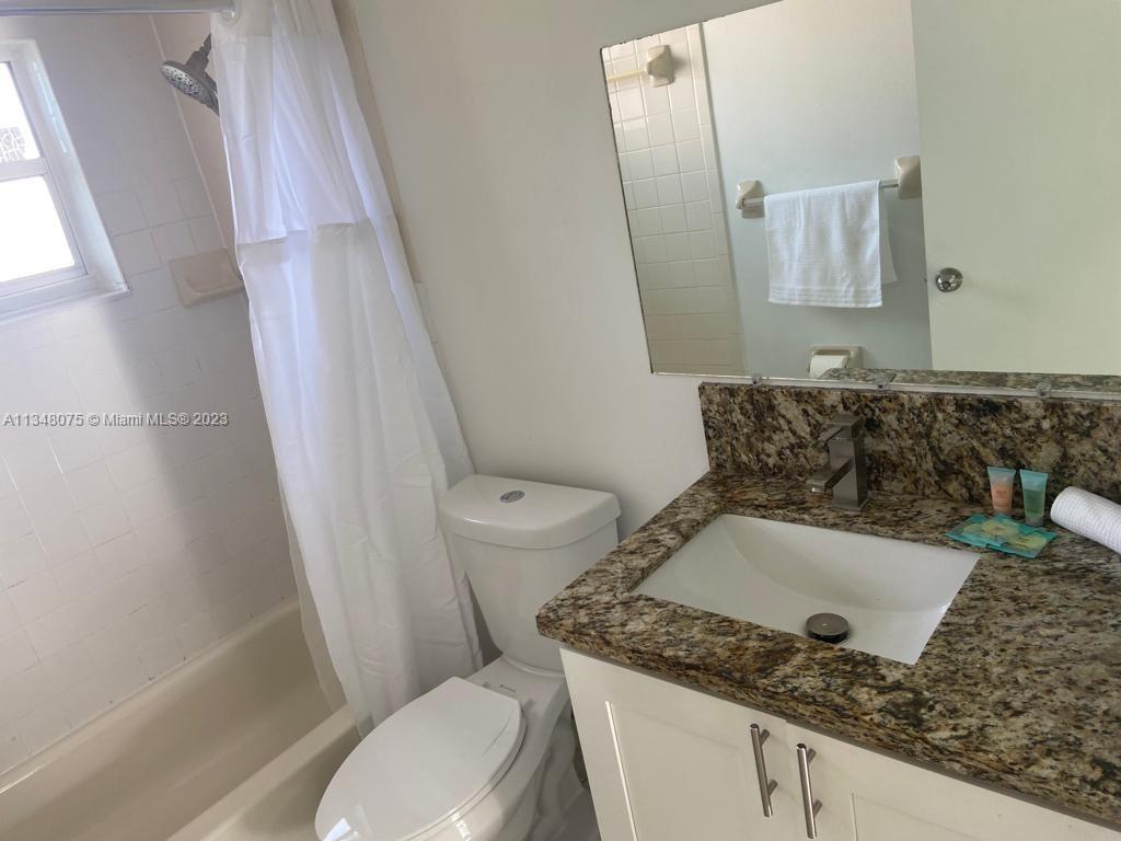1016 Southwest 8th Street Hallandale Beach, FL 33009 - Photo 10 of 18 a bathroom with a granite countertop sink toilet and shower