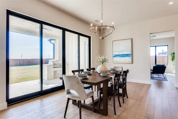 a kitchen with stainless steel appliances kitchen island granite countertop a table chairs and a refrigerator
