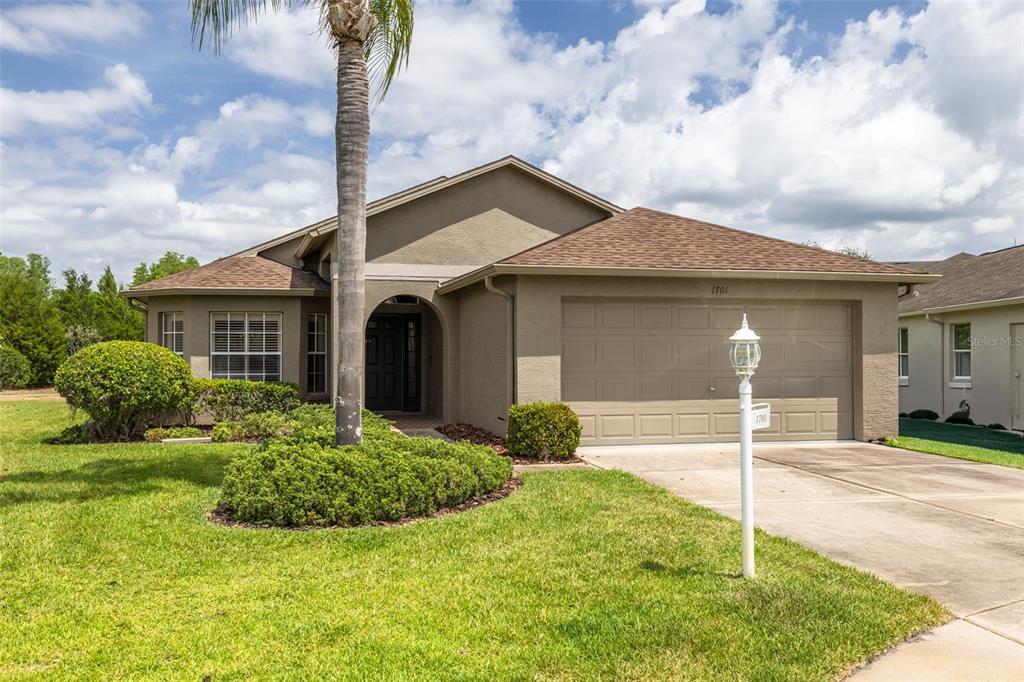 1701 Westerham Loop Trinity, FL 34655 - Photo 32 of 40 a front view of a house with a garden and plants