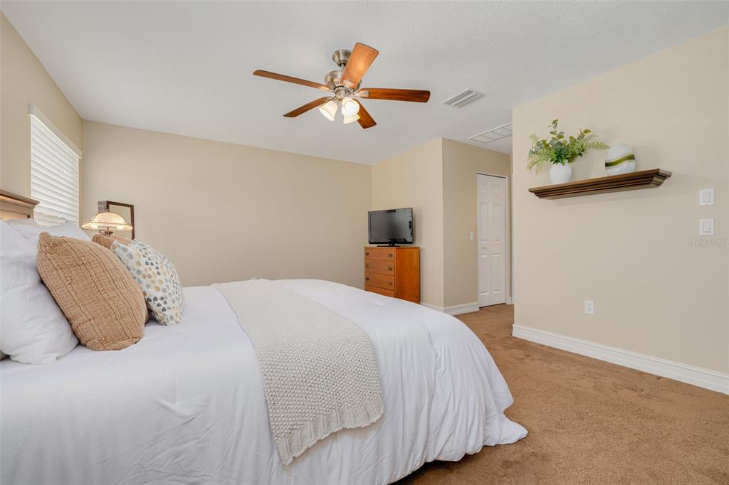 1701 Westerham Loop Trinity, FL 34655 - Photo 8 of 40 a bedroom with a bed and a chandelier