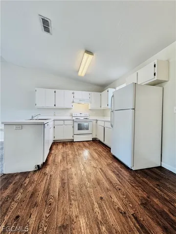 a kitchen with a refrigerator and white cabinets