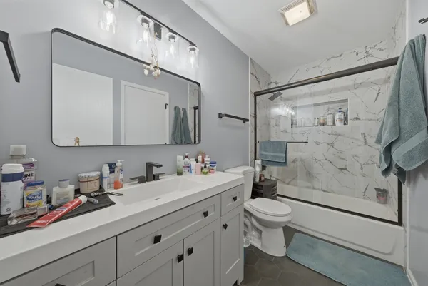 a bathroom with a sink a toilet and shower