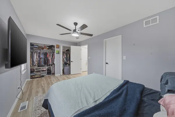a spacious bedroom with a bed and a flat screen tv
