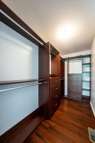 a view of walk in closet with wooden floor