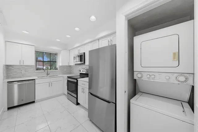 a kitchen with stainless steel appliances granite countertop a refrigerator and a stove top oven