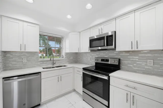 a view of a refrigerator in kitchen and an empty room