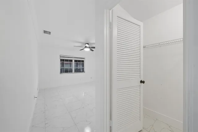 an empty room with chandelier fan