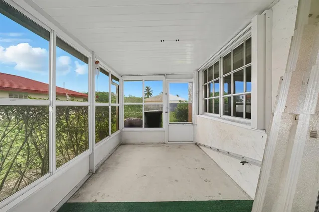 a view of a big room with a chandelier fan and windows