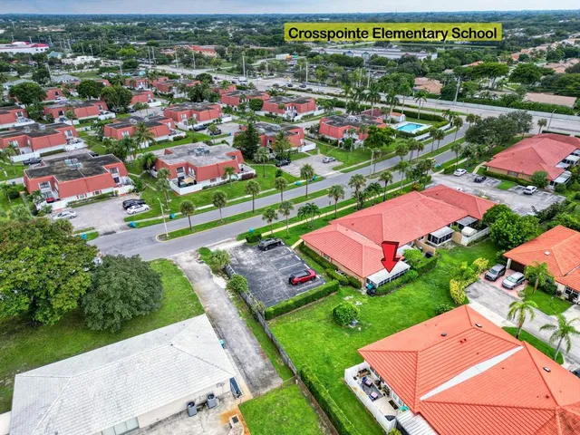 an empty room with white walls and chandelier fan