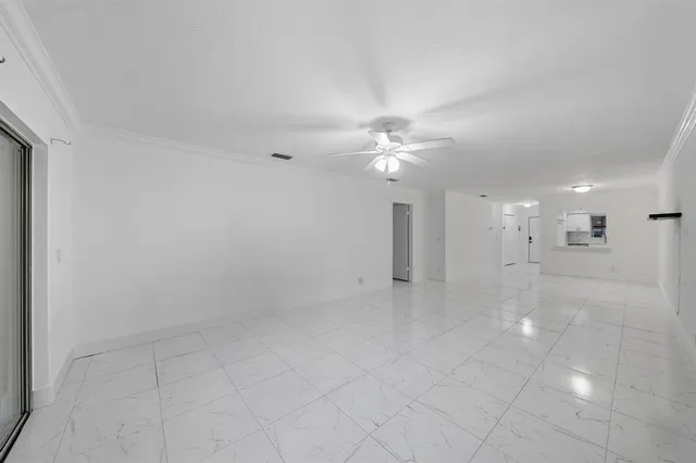 an empty room with white cabinet and mirrors