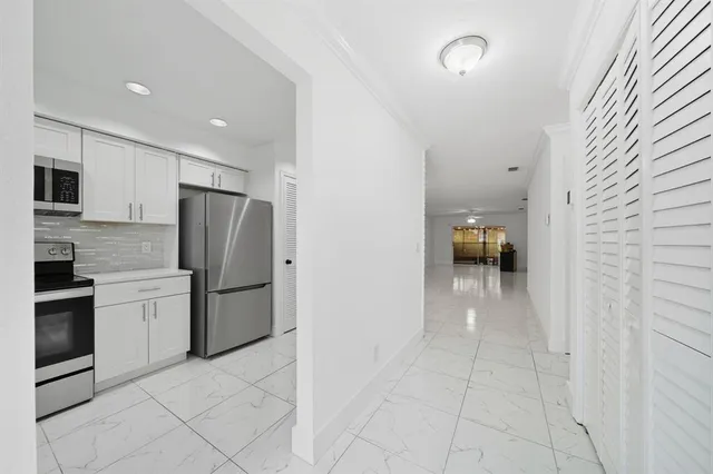 a kitchen with granite countertop a stove microwave and refrigerator