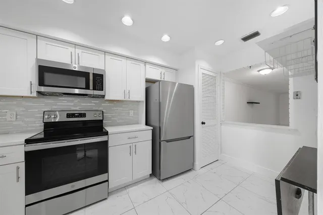 a kitchen with a refrigerator sink and stove top oven