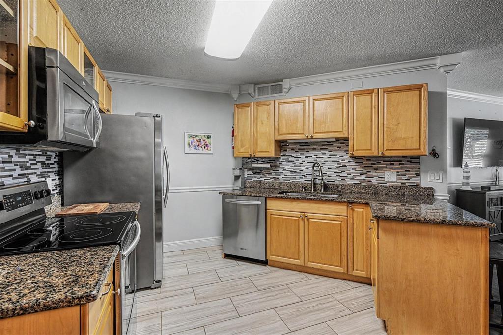 1550 South Belcher Road, Unit 525 Clearwater, FL 33764 - Photo 13 of 28 a kitchen with stainless steel appliances granite countertop a stove sink and cabinets