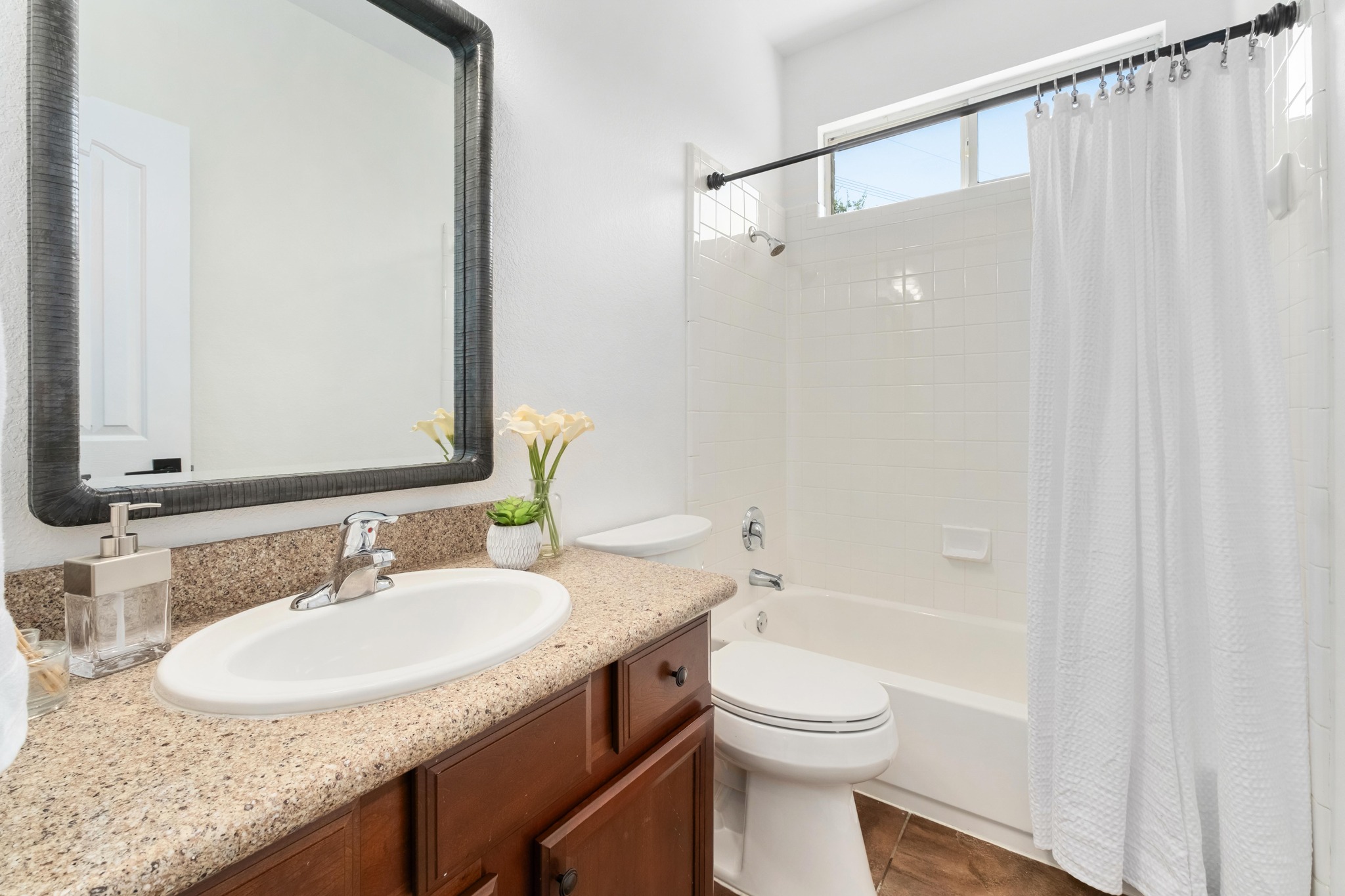 16200 Spillman Ranch Loop Austin, TX 78738 - Photo 29 of 36 A well-appointed bathroom offers a convenient shower-over-tub setup with warm wood-tone flooring.
