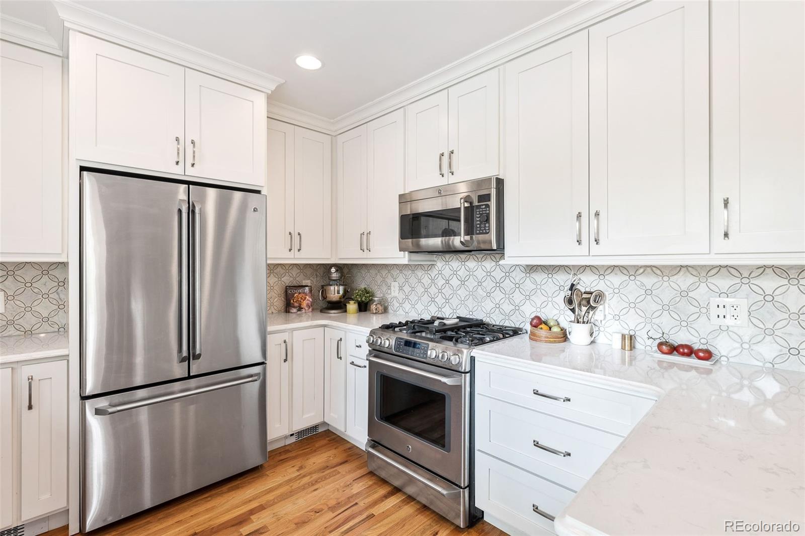 1205 Niagara Street Denver, CO 80220 - Photo 12 of 38 a kitchen with stainless steel appliances white cabinets and a refrigerator