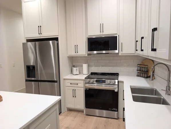 a kitchen with stainless steel appliances a stove microwave and refrigerator