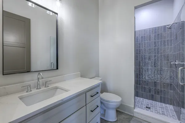a bathroom with a granite countertop sink toilet and shower