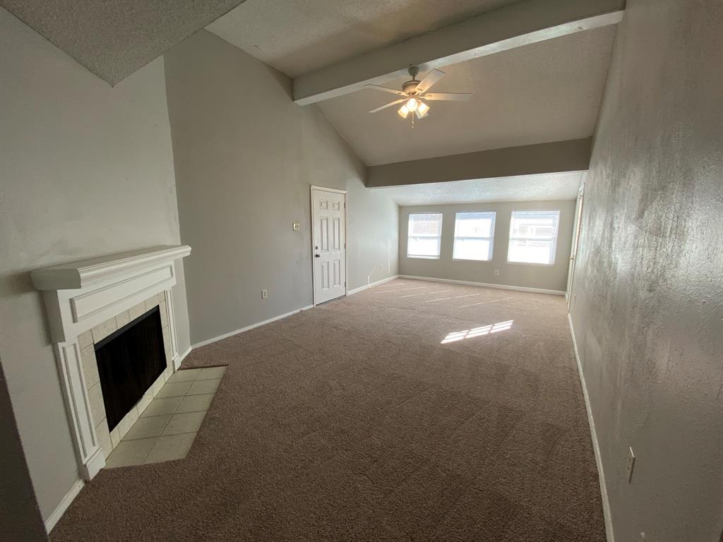 a view of empty room with window and fireplace