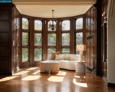 a living room with furniture a fireplace and large windows