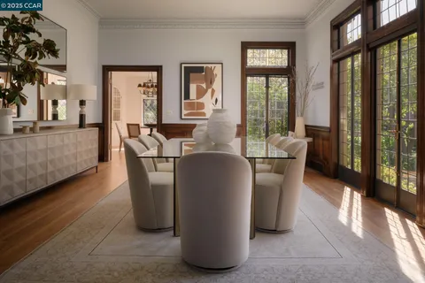 a kitchen with stainless steel appliances granite countertop a sink a stove a dining table and chairs