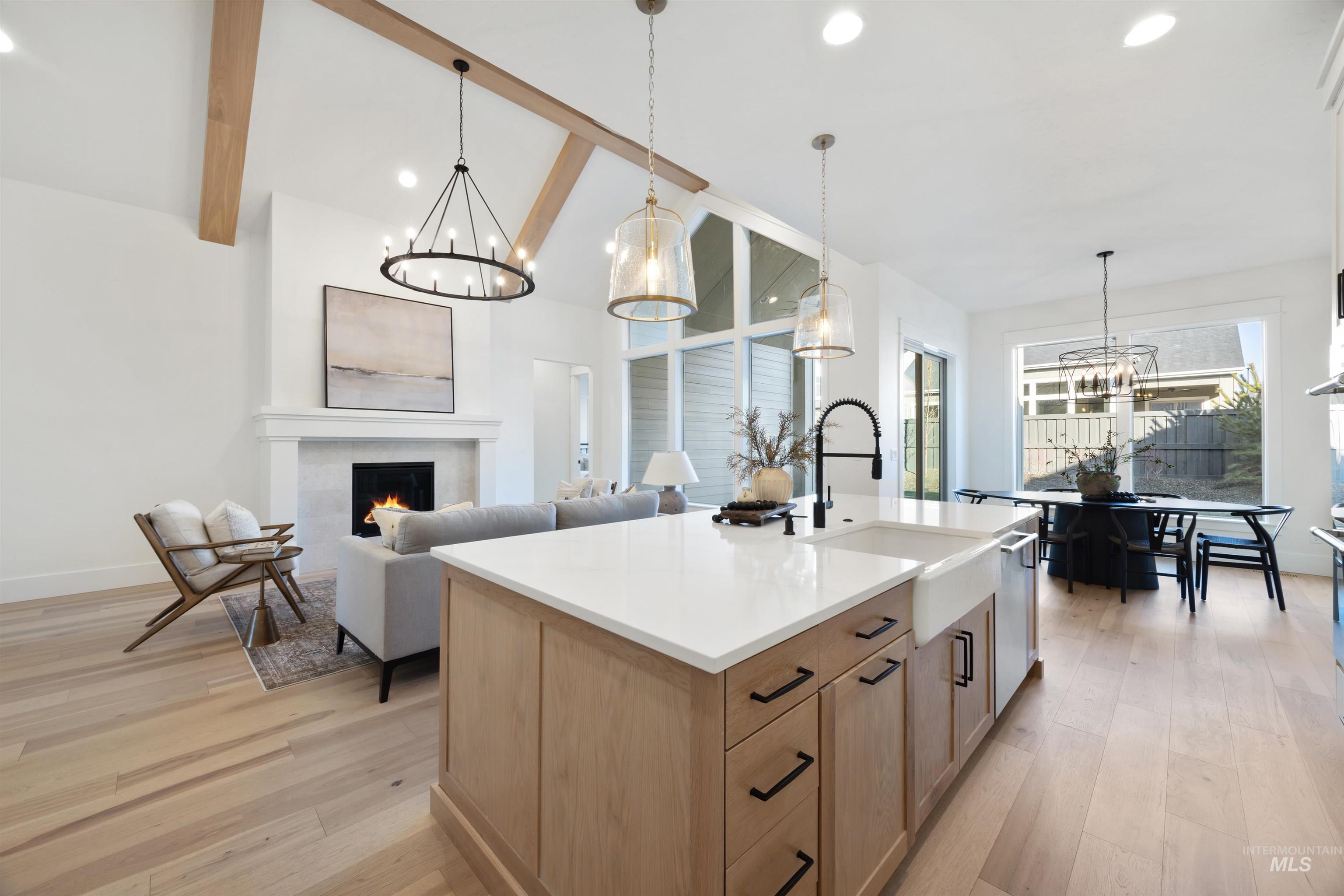 1034 East Escalation Street Meridian, ID 83642 - Photo 11 of 40 Kitchen featuring a chandelier, pendant lighting, a lit fireplace, light wood finished floors, and recessed lighting